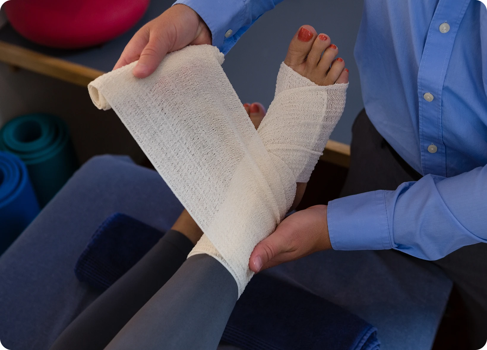 Verzorger legt een drukverband aan om een enkel tijdens een EHBO-oefening.